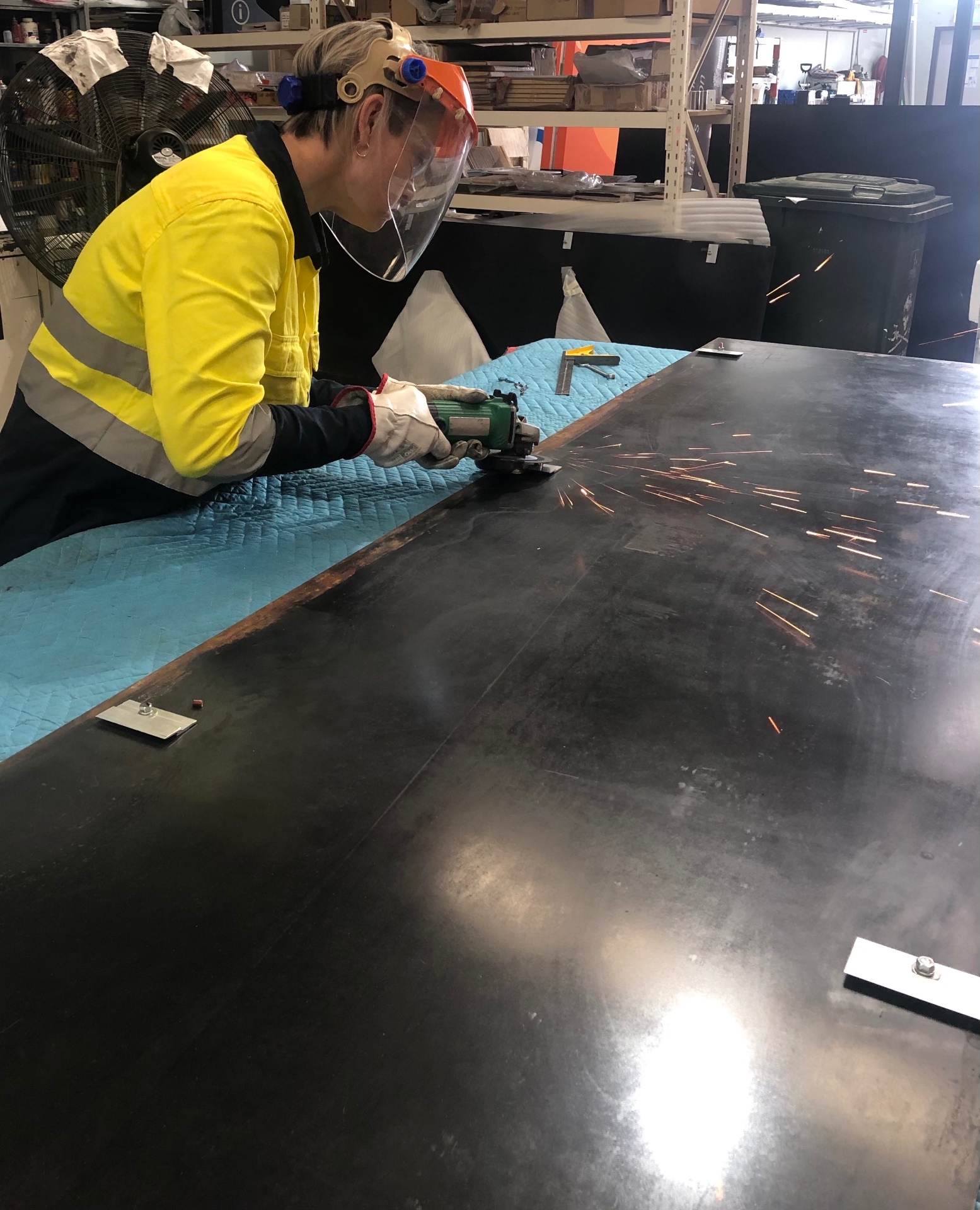 Hands crafting a wooden sign in a sunlit workshop